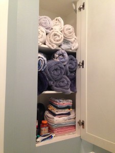 An organized towel closet consisted of top two shelves of rolled up towels. The 3rd shelf or bottom is for storing hand towels that's folded. 