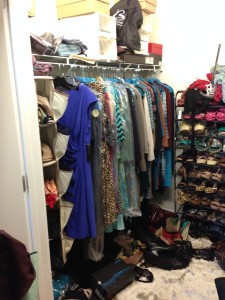 Picture of walk-in closet in chaos and underutilized with shoe boxes piled up on a single shelf above the rod. Purses, shoes and items on the floor. Stand alone tall shoe rack is shown piled over with shoes and clothes.