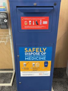 Blue drop-off bin to safely dispose of expired or unwanted medicine. Looks like a mailbox. 